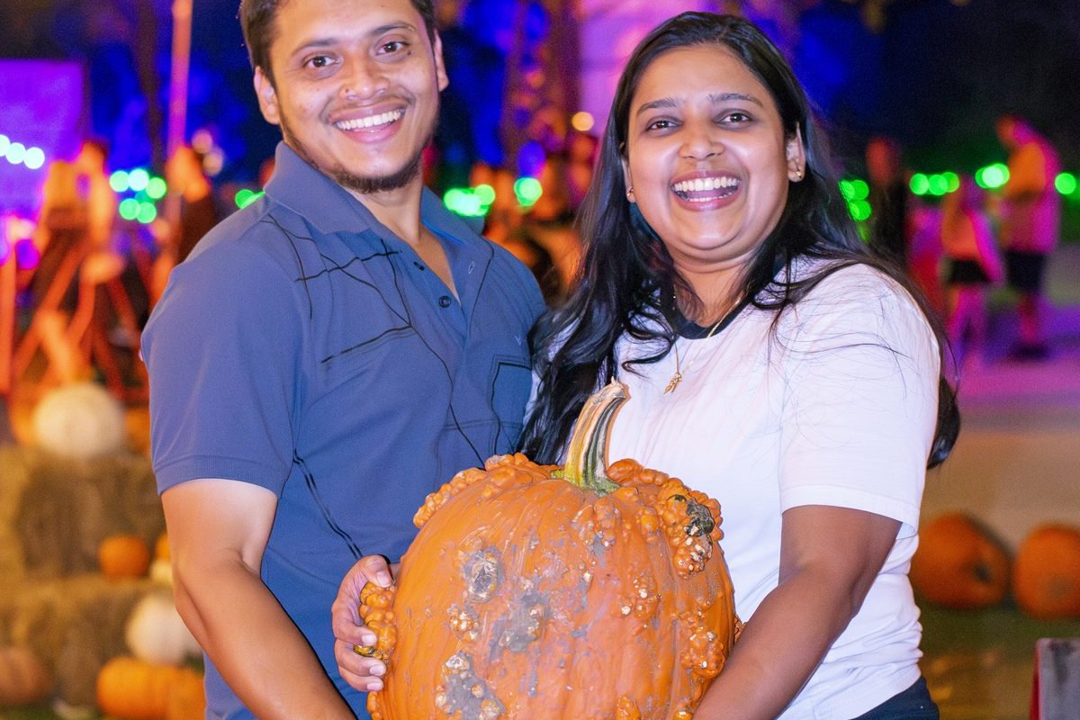 A couple with a carved pumpkin on the trail