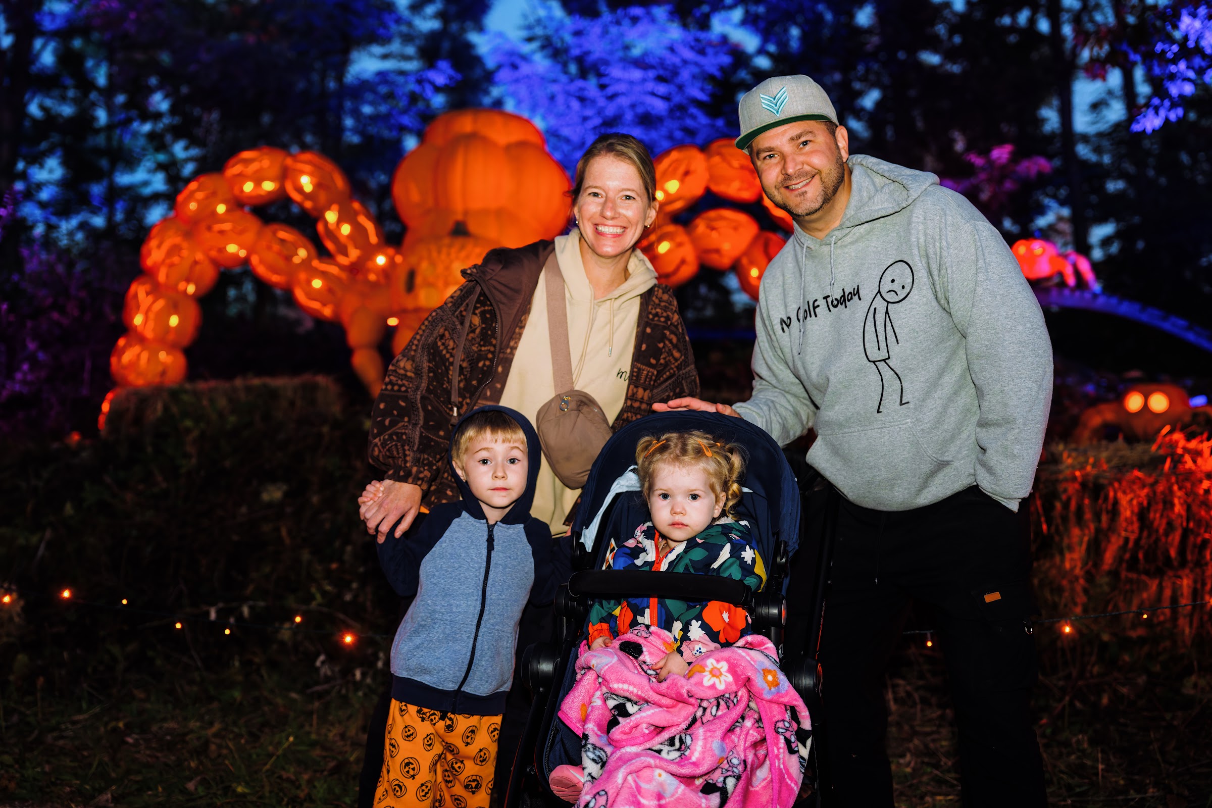 A family posing in front of the giant glowing pumpkin kraken